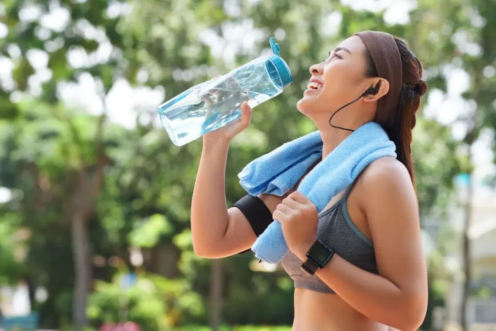 mulher bebendo agua apos exercicio